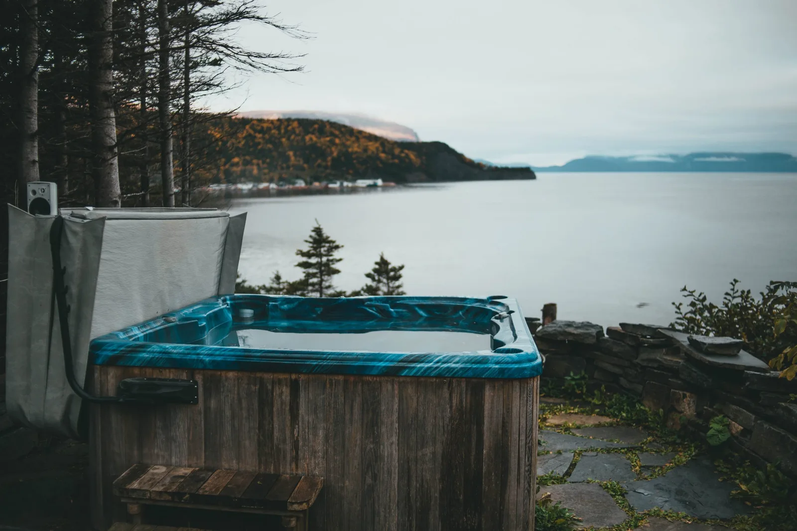 An outdoor hot tub overlooking a quiet lake